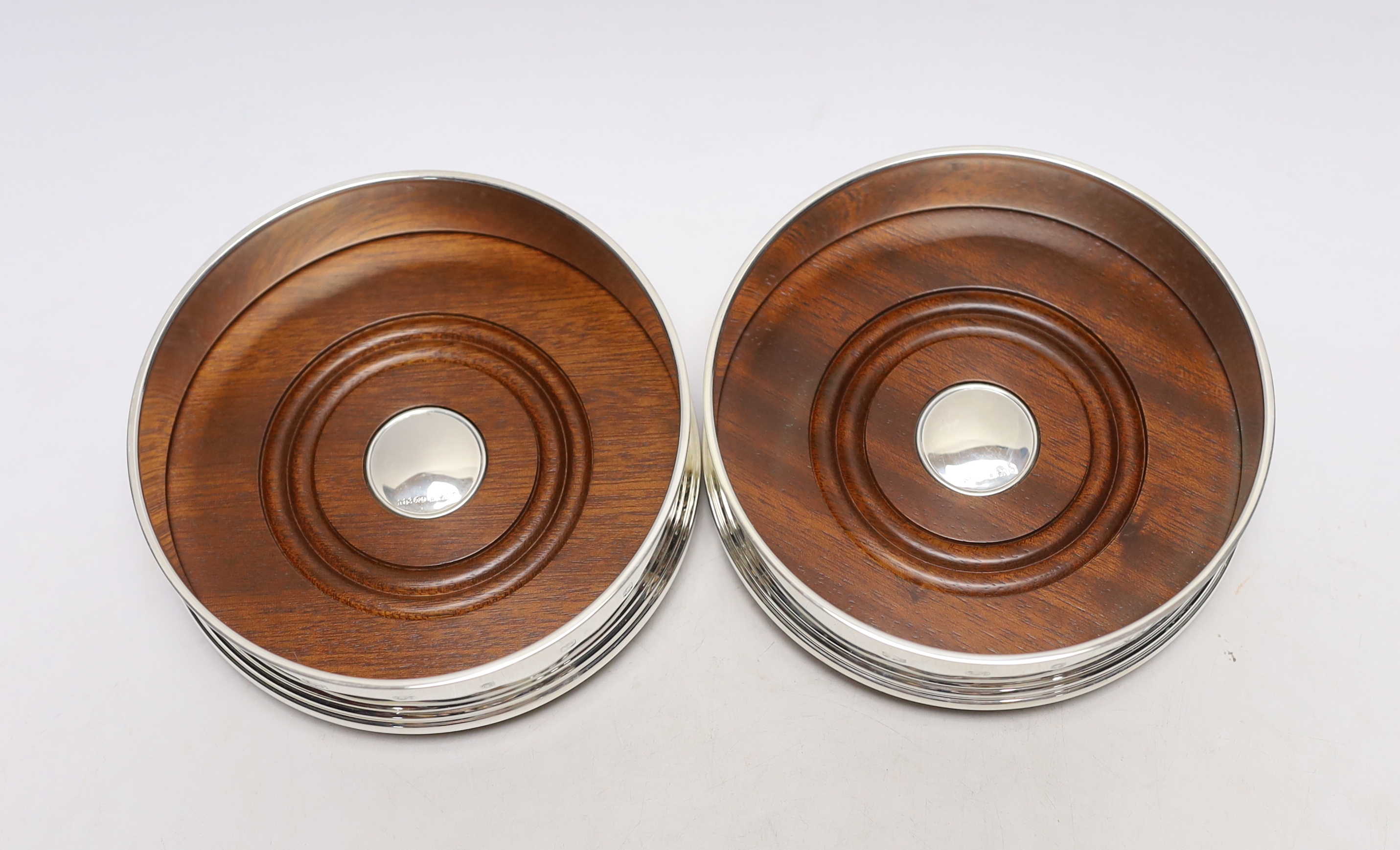 A pair of Elizabeth II silver mounted wine coasters, with turned wooden bases, Roberts & Dore, Sheffield, 2002, diameter 12.4cm, each individually boxed.